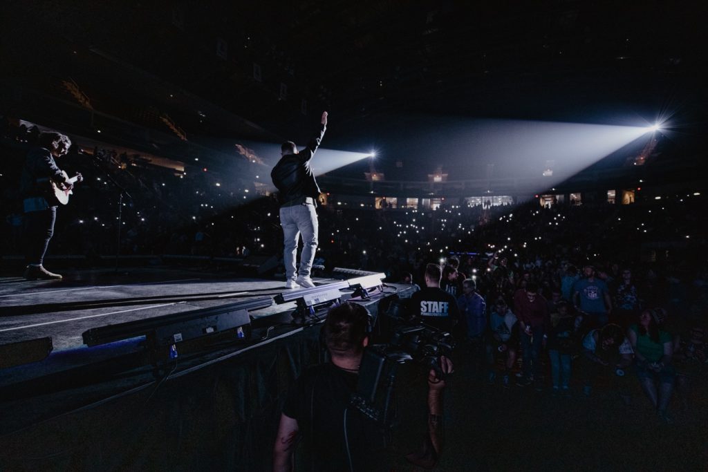 An artist performing in a crowded arena