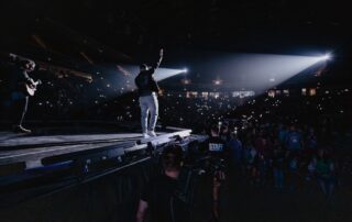 An artist performing in a crowded arena