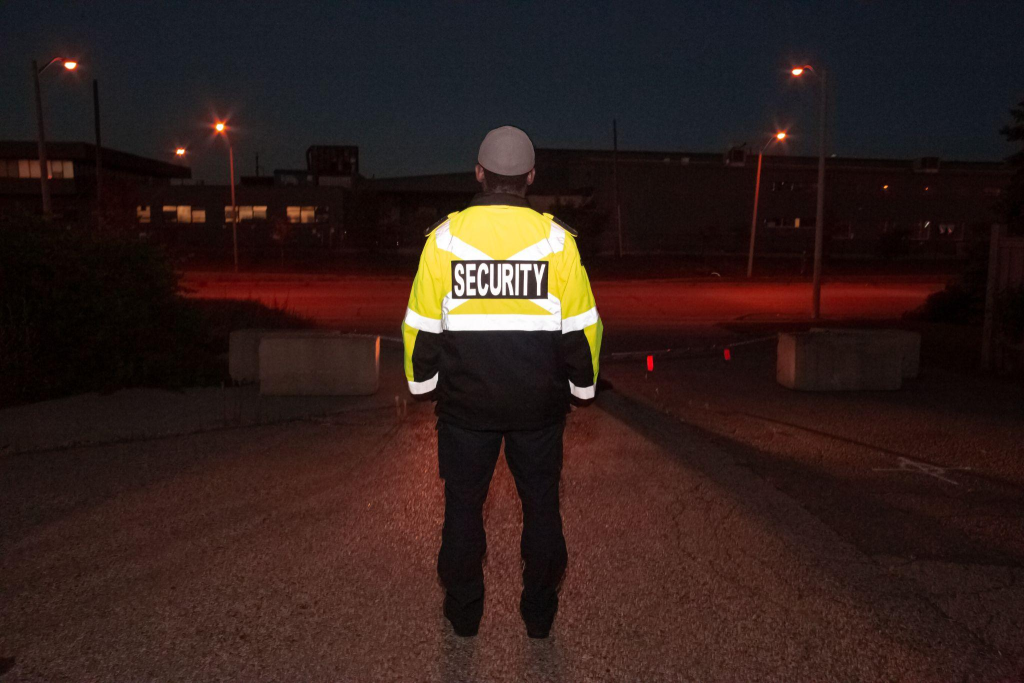 Back shot of an off-duty police officer guarding a road