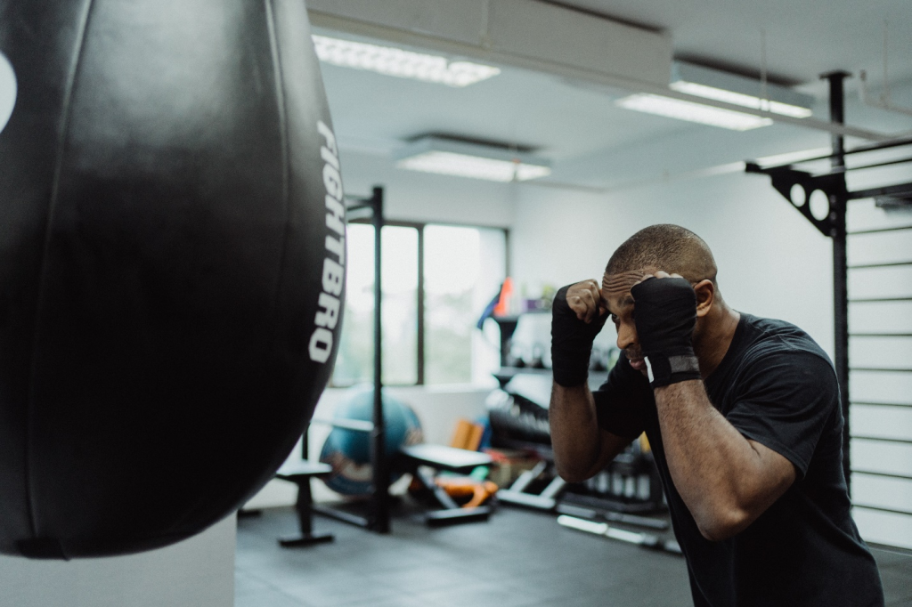 A man in a boxing ring is punching a punching bag.