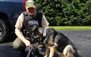 An armed security guard with a dog