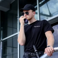 A man wearing sunglasses and a hat holding a microphone.