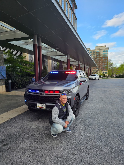This photo shows a security guard near a police car in an operational area.