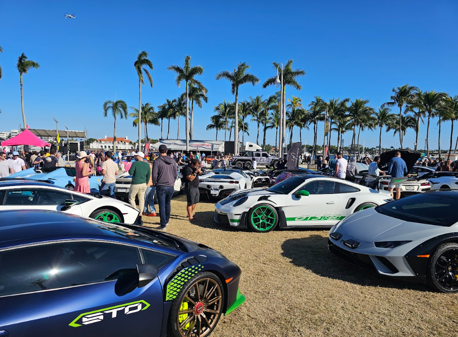 This photo shows cars surrounded by people