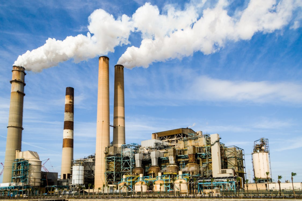A factory with smoke coming out of the chimneys.