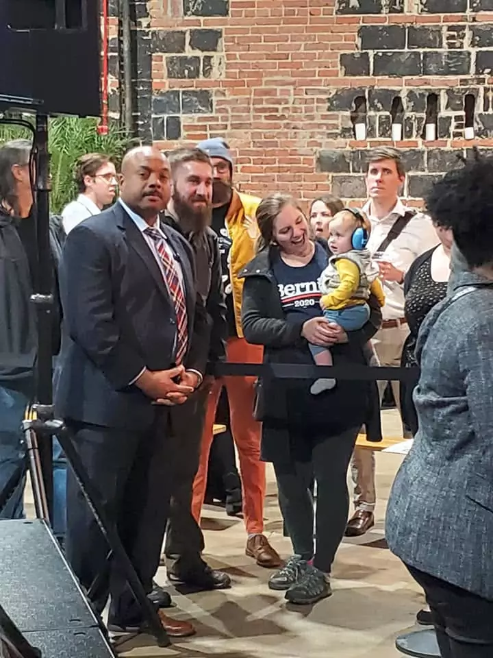 A group of people standing around a building.