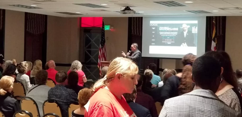 A man giving a speech in front of a crowd of people.