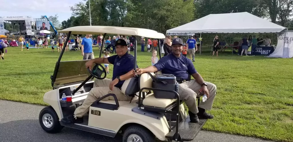 Two men sitting in a golf cart on a golf course.
