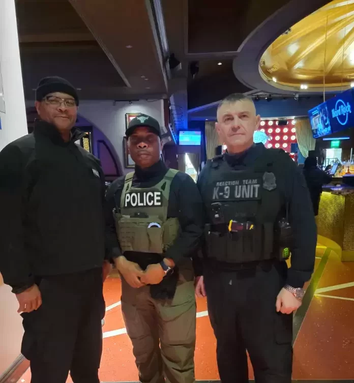 Three men in police uniforms are standing in a room.