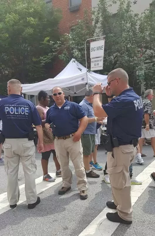A group of people standing around a white tent.