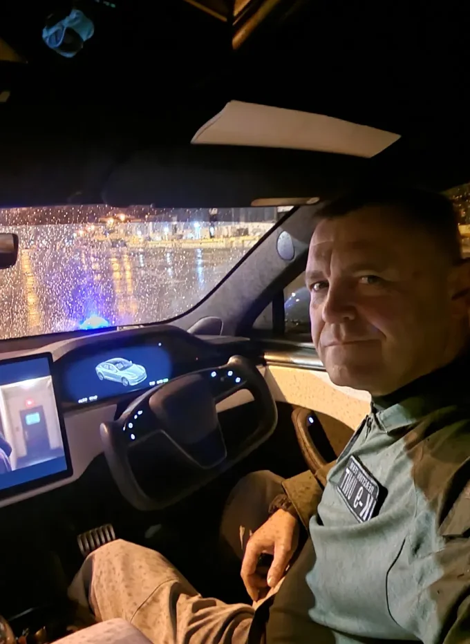 A man driving a car with a video game on the screen.